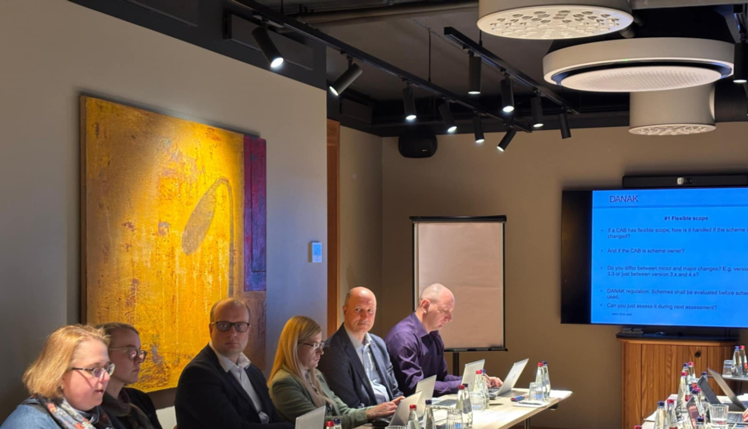 dažādi cilvēki pie galdiem, diskutē par apskatāmo tēmu