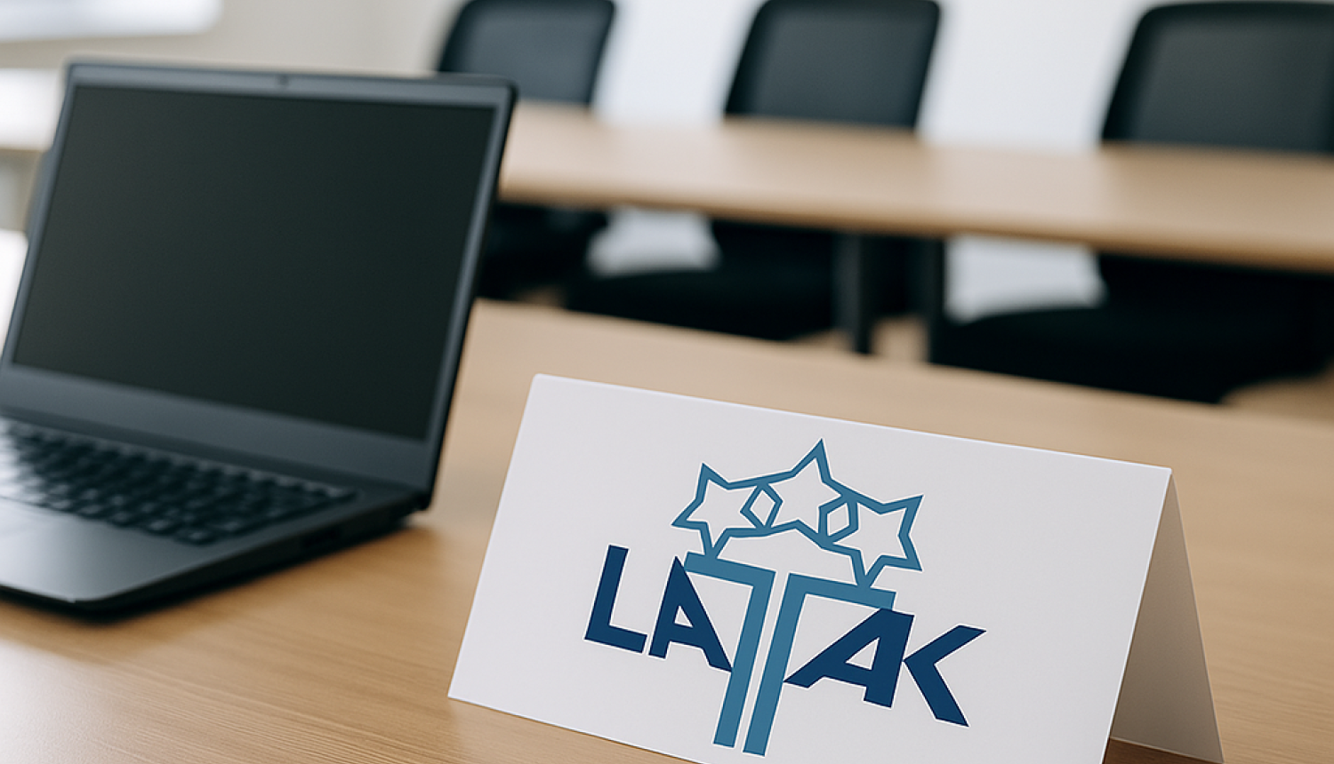 sanāksmju telpa, dators, galda karte ar LATAK logo, fona biroja krēsli
